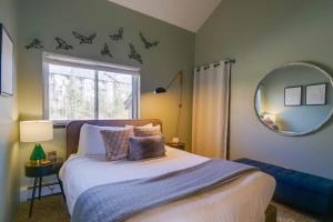 una camera da letto con un letto, uno specchio e una finestra di Top Floor Corner with Views 6 Ski Resorts Nearby a Silverthorne