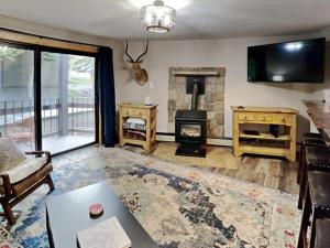 a living room with a fireplace and a tv at Stylish 2BR Home Near Skiing with Hot Tub Access in Breckenridge