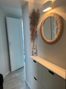 um espelho na parede por cima de uma cómoda num quarto em VO apartments em Juodkrantė