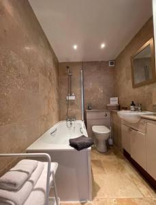 a bathroom with a tub and a toilet and a sink at Brewers Den a Beautiful 1-Bed Apartment in Masham in Ripon