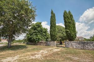 a stone wall with trees and a fence at Ferienhaus mit Privatpool für 8 Personen ca 150 qm in Červari, Istrien Westküste von Istrien in Kanfanar