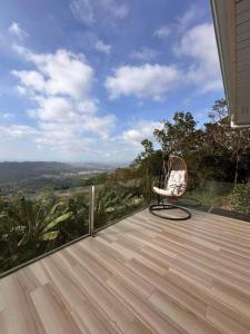 una silla sentada en la cubierta de una casa en Veronica Guesthouse w/ Breathtaking Mountain View, en Bagolig