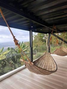 two hammocks hanging in a room with a window at Veronica Guesthouse w/ Breathtaking Mountain View in Bagolig