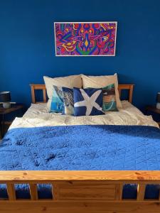 Dormitorio azul con cama con marco de madera en Gemütliche, sonnendurchflutete Ferienwohnung in Bodenseenähe am Säntisblick, en Herdwangen-Schönach