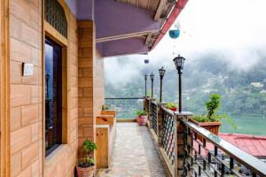 un balcón de un edificio con vistas al agua en Goroomgo Vinayak Mall Road Lake View Nainital - Luxury Room - Best Hotel in Nainital en Nainital