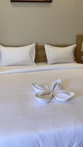 una manta blanca con un arco en la cama en سيال 1, en Al Ula