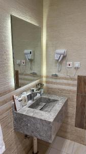 y baño con lavabo de piedra y espejo. en سيال 1, en Al Ula