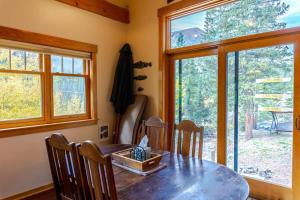 a dining room with a table and chairs and windows at Tranquil 3BR Home Access To Trails and Mtn Views in Blue River