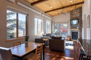 a living room with a table and a fireplace at 2BR Riverside Cabin Near Trails with Hot Tub Access in Breckenridge