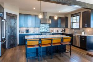 ブリッケンリッジにあるLuxurious 4BR with Hot Tub and Stunning Mountain Viewsのキッチン(青いキャビネット、黄色のバースツール付)