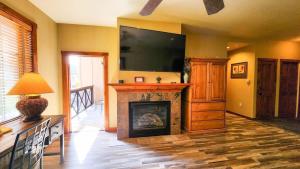 a living room with a fireplace and a flat screen tv at Main St Station Condo with Hot Tub and Parking in Breckenridge