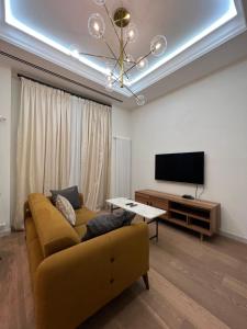 un soggiorno con divano e TV a schermo piatto di ARP_apartments a Baku