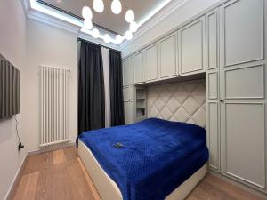 a bedroom with a bed with a blue blanket at ARP_apartments in Baku