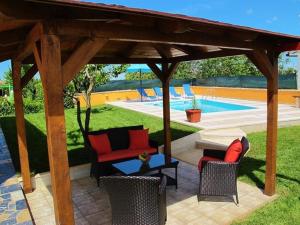 a pavilion with chairs and a table next to a pool at Ferienhaus mit Privatpool für 6 Personen ca 90 qm in Sveti Petar u Sumi, Istrien Binnenland von Istrien in Sveti Petar u Šumi