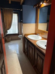 a bathroom with two sinks and a mirror and a toilet at Prima Luce Village in Saint Vincent