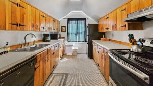 a kitchen with wooden cabinets and a sink and a stove at 1BR Rustic Retreat Near Trails and Slopes in Dillon