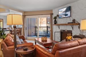 2BR Condo in the Heart of Breck في بريكنريدج: غرفة معيشة مع أثاث من الجلد ومدفأة