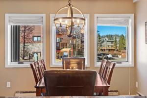 a dining room with a table and chairs and windows at 2BR Condo in the Heart of Breck in Breckenridge