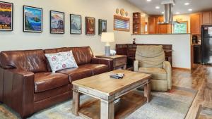 a living room with a brown leather couch and a table at Bright Baldy 2BD Near Trailheads in Breckenridge