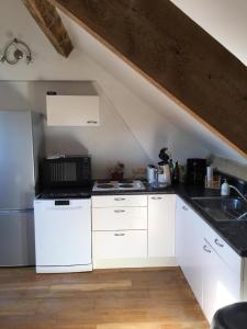 una cucina con mobili bianchi e un lavandino di Knokke - Ein-Zimmer-Wohnung in der Nähe von Stränden a Knokke-Heist