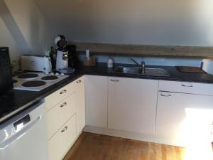 una cucina bianca con lavello e fornello di Knokke - Ein-Zimmer-Wohnung in der Nähe von Stränden a Knokke-Heist