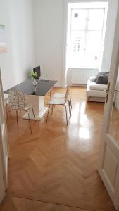 uma sala de estar com uma mesa e cadeiras e um sofá em Sobieski Stefansdom Apartments em Viena