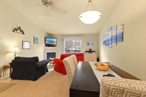 a living room with a red couch and a table at 2BR Condo - Ideal Hub for Year-Round Fun in Silverthorne