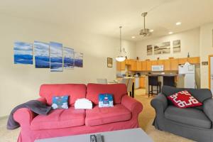 a living room with a red couch and a kitchen at 2BR Condo - Ideal Hub for Year-Round Fun in Silverthorne