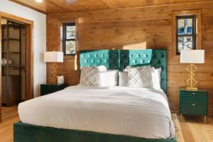 a bedroom with a large bed with a green headboard at 3BR+Loft Modern Mountain Retreat w Hot Tub in Alma