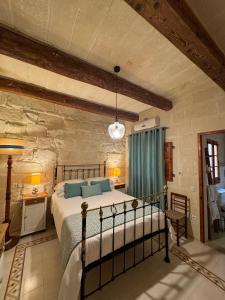 a bedroom with a bed in a stone wall at Maria's B&B in Għasri