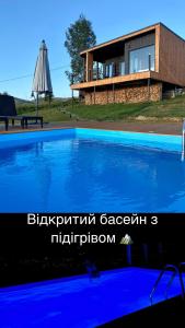 uma casa com piscina em frente a uma casa em Under_sky_slavske em Slavske