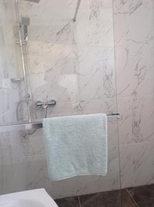 a bathroom with a white towel hanging from a shower at Panorama Studio in Skradin