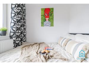um quarto com uma cama com um quadro na parede em Lavender Room em Gdańsk