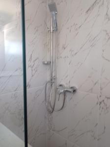 a shower in a bathroom with white marble walls at Panorama Studio in Skradin +19 photos