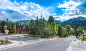 an empty street in a town with mountains in the background at Gorgeous View in Town Walk to Lifts in Breckenridge