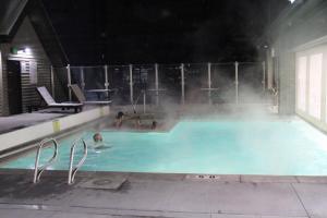 a group of people in a swimming pool at night at Breathtaking Mountain Views- Ski-in out 2BR Condo in Park City