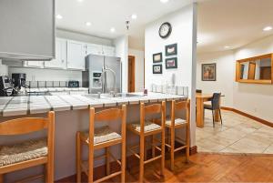 a kitchen with a counter with chairs and a sink at Stunning Location 2BDR Condo Retreat in Park City