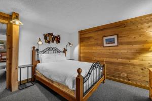 ein Schlafzimmer mit einem Bett mit einer Holzwand in der Unterkunft Centrally Located 1 BDR Condo Near Everything in Park City