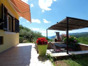 a patio of a house with a table and flowers at Ferienhaus mit Privatpool für 6 Personen ca 85 qm in Rabac, Istrien Bucht von Rabac in Rabac