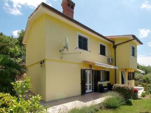 a yellow house with its door open on a yard at Ferienhaus mit Privatpool für 6 Personen ca 85 qm in Rabac, Istrien Bucht von Rabac in Rabac