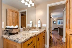 a bathroom with a sink and a large mirror at Quaint 2BR Retreat Heart of Town Steps from Lift in Park City +20 photos