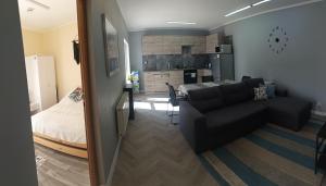 een woonkamer met een bank en een slaapkamer bij Zacisze, domek na wsi blisko Trójmiasta in Wiślinka