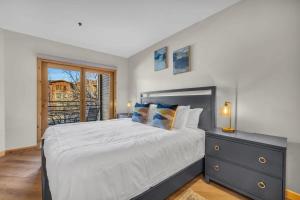 a bedroom with a large bed and a window at Steps From Ski Lift Garage Parking Included in Park City