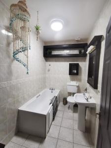 La salle de bains est pourvue d'une baignoire, de toilettes et d'un lavabo. dans l'établissement Palm Cove Bundoran Luxurious Sea View Balcony Free Wifi Netflix Sleeps 5, à Bundoran