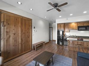 a kitchen with wooden cabinets and a ceiling fan at Cozy Ski In Ski Out Studio with Hot Tub Access in Park City