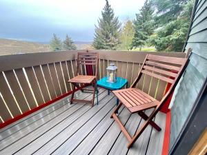 a porch with two chairs and a table and a lantern at Stylish 2BR Condo Near Olympic Park and Ski Resorts in Park City