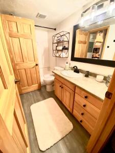a bathroom with a sink and a toilet and a mirror at Stylish 2BR Condo Near Olympic Park and Ski Resorts in Park City