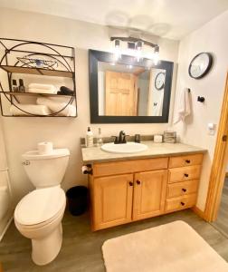 a bathroom with a toilet and a sink and a mirror at Stylish 2BR Condo Near Olympic Park and Ski Resorts in Park City
