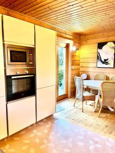 a kitchen with a table and a refrigerator and a table at Les Villas d' Onalou Port Blanc in Penvénan