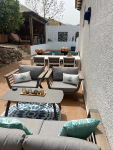 een patio met banken en tafels en een zwembad bij Lovely Apartment Orba Alicante in Orba